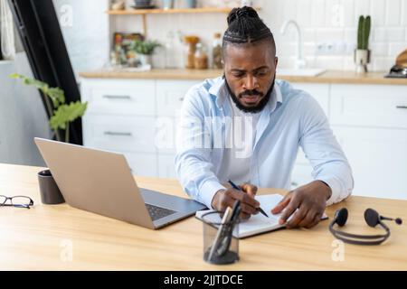 African American confident businessman using laptop computer working from home Remote work concept Stock Photo
