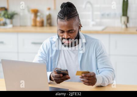 Portrait of smiling man uses secure internet banking to pay for services online using mobile phone Stock Photo