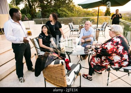 Diverse people socializing at an outdoor cocktail party in Johannesburg Stock Photo