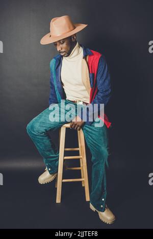 An African American man from US in a hat and casual outfit posing in a photo studio Stock Photo