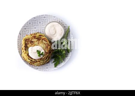 Zucchini fritters with yogurt sauce isolated on white background Stock Photo