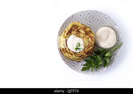 Zucchini fritters with yogurt sauce isolated on white background Stock Photo