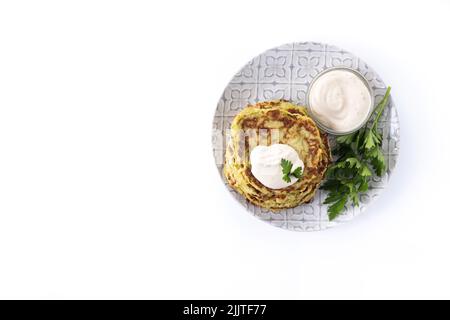 Zucchini fritters with yogurt sauce isolated on white background Stock Photo