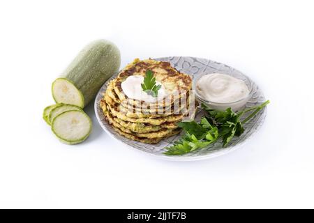 Zucchini fritters with yogurt sauce isolated on white background Stock Photo