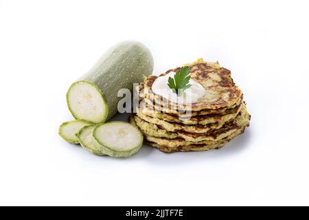 Zucchini fritters with yogurt sauce isolated on white background Stock Photo