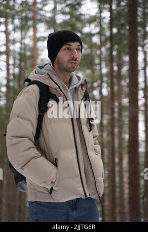A vertical portrait of a young caucasian man in a winter forest Stock Photo