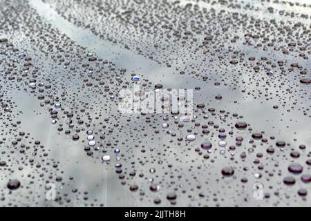 A full-frame shot of rain drops on a grey glossy surface Stock Photo