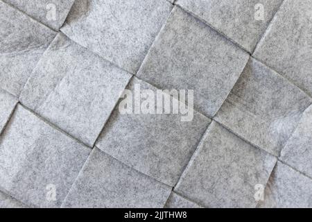 Abstract gray felt background. Home storage basket made of soft grey felt material. Surface of felted wool fabric texture. Close-up, square pattern Stock Photo