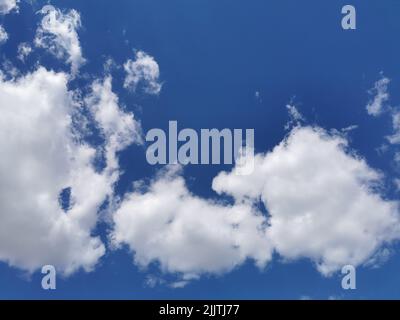 Beautiful fluffy clouds in the endless blue sky Stock Photo