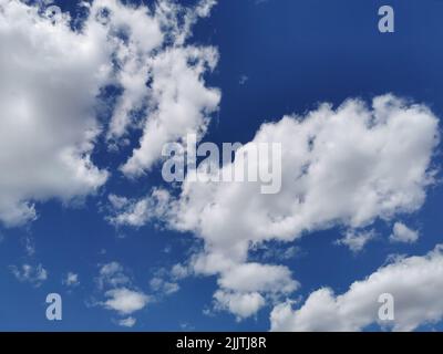 A beautiful view of white fluffy clouds in the clear sky Stock Photo