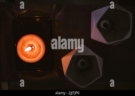 A top view of burning candle on a decorative tray and candle holders Stock Photo