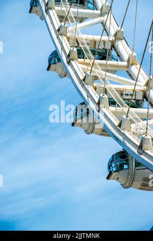 A vertical closeup shot of the Ain Dubai Ferris wheel against a blue sky in Bluewaters Island, Dubai, United Arab Emirates Stock Photo