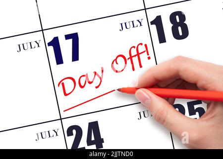 17th day of July. Hand writing text DAY OFF and drawing a line on calendar date 17 July. Vacation planning concept. Summer month, day of the year conc Stock Photo