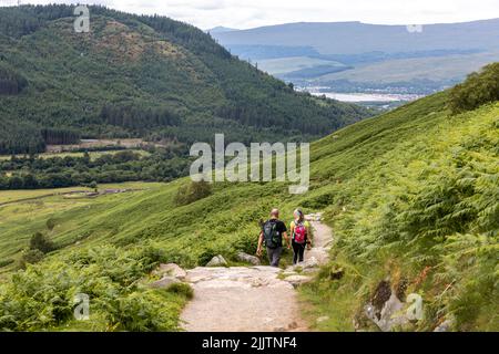 Male and female walkers hikers descend after climbing Ben Nevis, Britains highest mountain,Scotland,Uk on a summers day Stock Photo