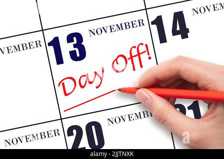 13th day of November. Hand writing text DAY OFF and drawing a line on calendar date 13 November. Vacation planning concept. Autumn month, day of the y Stock Photo