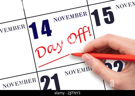 14th day of November. Hand writing text DAY OFF and drawing a line on calendar date 14 November. Vacation planning concept. Autumn month, day of the y Stock Photo