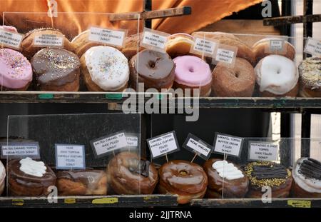 Various doughnuts for sale at a stall in Camden market Stock Photo