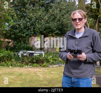 The male adult man flying a drone using the controller Stock Photo