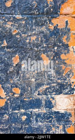 old peeled paint on blue and orange brick wall background Stock Photo