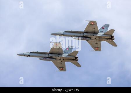 2 Swiss Air Force McDonnell Douglas F/A-18C Hornets arriving at RAF Fairford on the 14th July to take part in the Royal International Air Tattoo 2022 Stock Photo