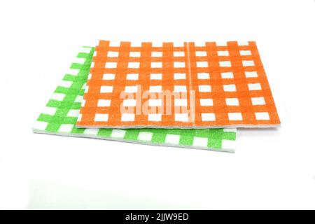 Clean sponge cloths with a checkered pattern isolated on white background. Household cleaning cloth. Closeup of cleaning rag. Stock Photo