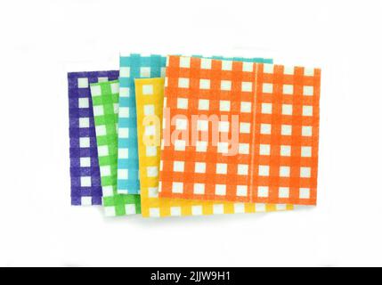 Clean sponge cloths with a checkered pattern isolated on white background. Household cleaning cloth. Closeup of cleaning rag. Stock Photo