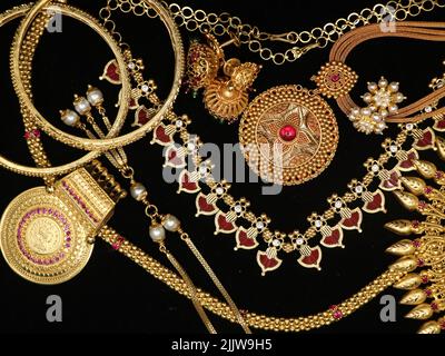 antique collection of vintage gold ornaments and jewelry for women used on auspicious occasions and weddings on a black background Stock Photo