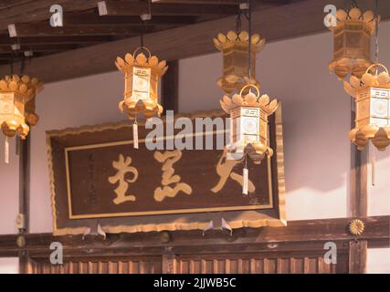 kyoto, japan - may 22 2022: Golden lanterns hung at Daikokuto hall which houses the deity of the wealth Daikokuten in the Buddhist Enryaku temple. Stock Photo
