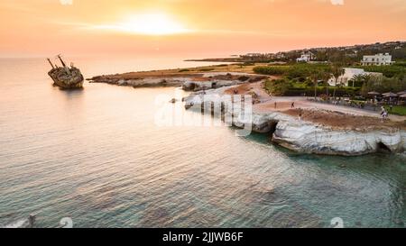 Aerial bird’s eye view of the abandoned ship wreck EDRO III in Pegeia, Paphos, Cyprus from above at sunset. The rusty shipwreck stranded on Peyia rock Stock Photo