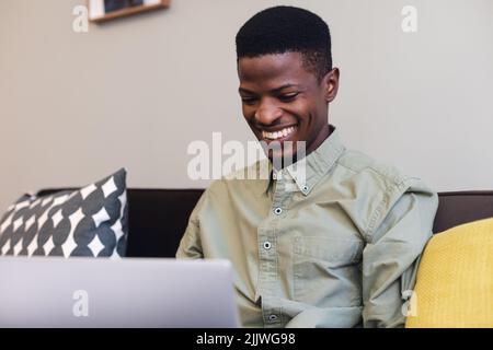 Smiling african american young businessman using laptop in office Stock Photo
