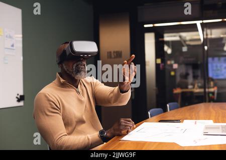 African american mature businessman using virtual reality simulator in office Stock Photo