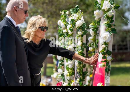 Uvalde, United States of America. 29 May, 2022. U.S First Lady Dr. Jill Biden reaches out to touch a wreath at a makeshift memorial as President Joe Biden looks on outside Robb Elementary School, May 29, 2022 in Uvalde, Texas. The school is the site where a gunman slaughtered 19 students and two teachers with a military style assault rifle.  Credit: Adam Schultz/White House Photo/Alamy Live News Stock Photo