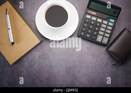 flat composition coffee, notepad and calculator on black background . Stock Photo