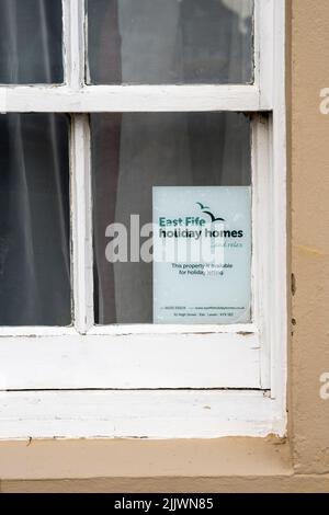 A sign in a cottage window in St Monans in the East Neuk of Fife reads: This property is available for holiday letting. Stock Photo