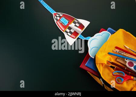 School backpack with colorful school supplies on table. Stock Photo