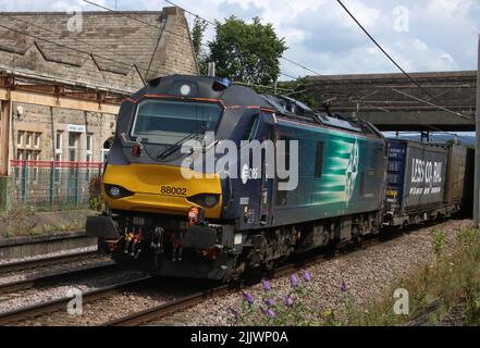 Direct Rail Services class 88 electro-diesel, 88002 Prometheus, passing Carnforth on West Coast Main Line with container train on 27th July 2022. Stock Photo