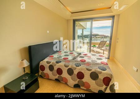 a small apartment bedroom with ocean landscape views over the Mediterranean coastline Stock Photo