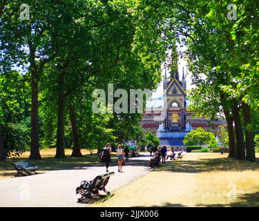 Scenic view looking down the path towards the rear of Albert Memorial, with the Albert Hall in the background on a bright summer day, framed by trees Stock Photo