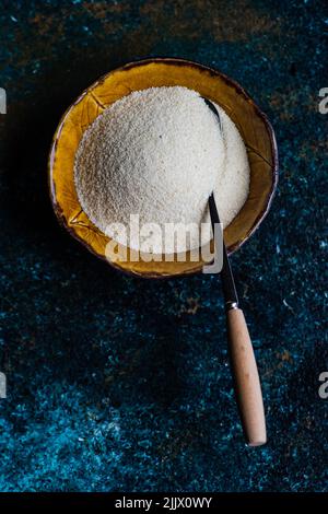 Top view of organic corn flour in the ceramic bowl on stone table Stock Photo