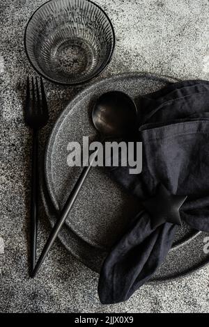 Minimalist black tableware set on dark concrete table Stock Photo