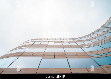 Low angle of modern curve high building with dense mirrored windows Stock Photo