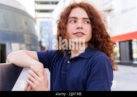Young Woman looking away while standing in city Stock Photo