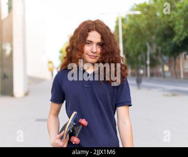 Portrait of young Woman with skateboard standing in city Stock Photo