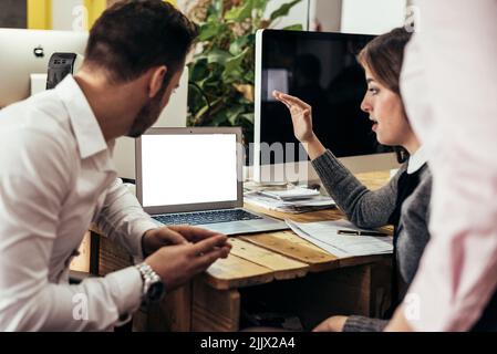 Focused man and Woman in formal wear looking at blank screen of netbook while working together on business project in office Stock Photo
