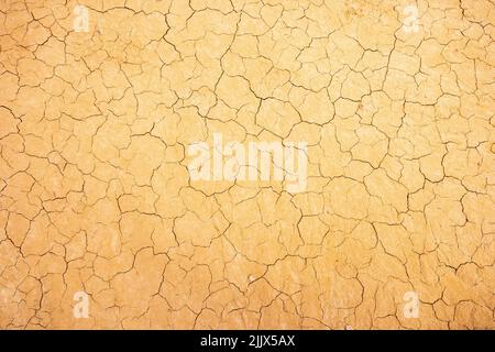 Top view closeup textured background of rough cracked barren waterless soil during drought Stock Photo