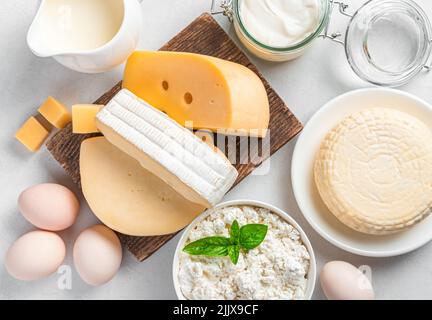 Different types of cheeses and dairy products on a gray background. Stock Photo
