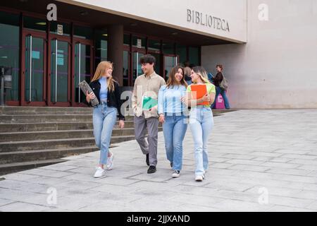 Group of college students leaving the library to study Stock Photo