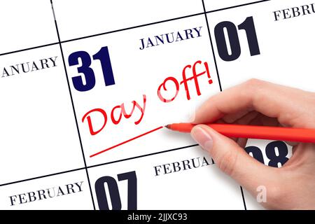 31st day of January. Hand writing text DAY OFF and drawing a line on calendar date 31 January. Vacation planning concept. Winter month, day of the yea Stock Photo