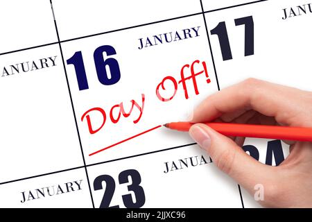 16th day of January. Hand writing text DAY OFF and drawing a line on calendar date 16 January. Vacation planning concept. Winter month, day of the yea Stock Photo