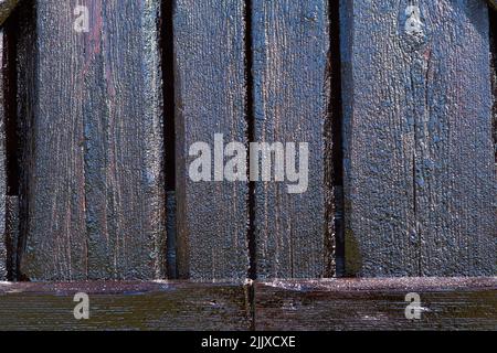 Wood and tar texture on some plank. Black wooden wall in bright sunshine. Recently tarred. Close up, macro. Stock Photo